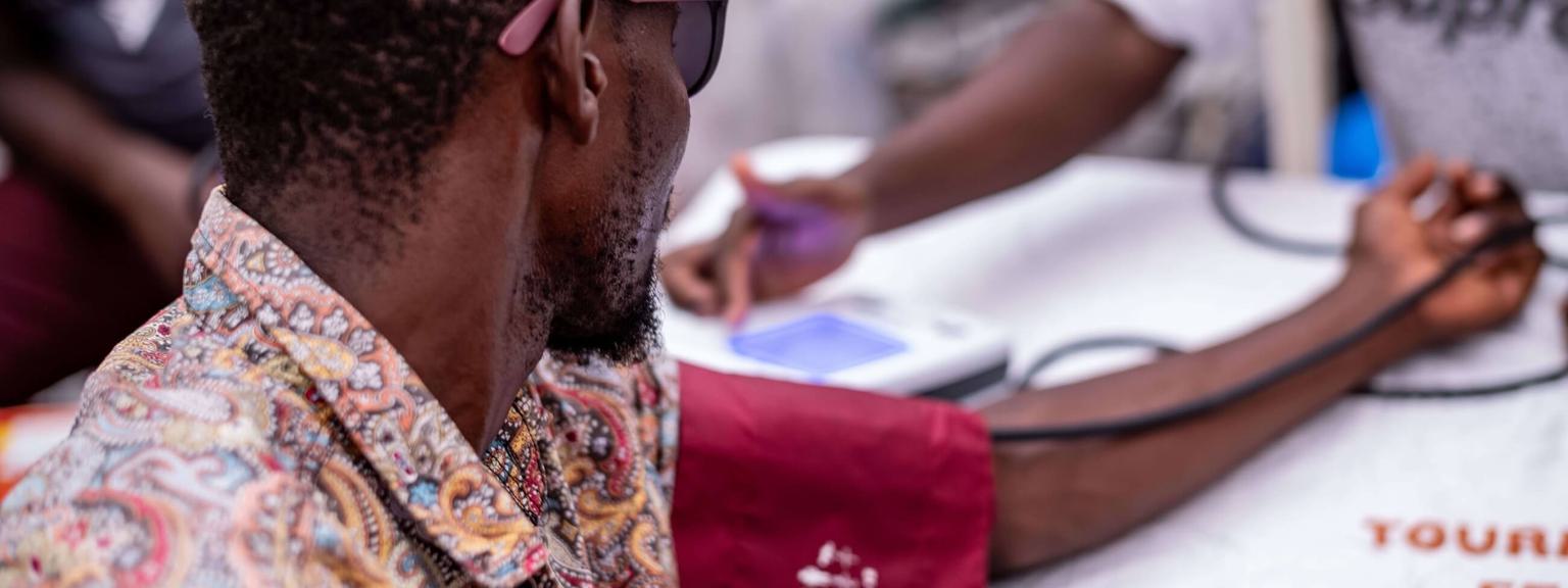 A man is hooked up to a device monitoring his blood pressure with his arm outstretched