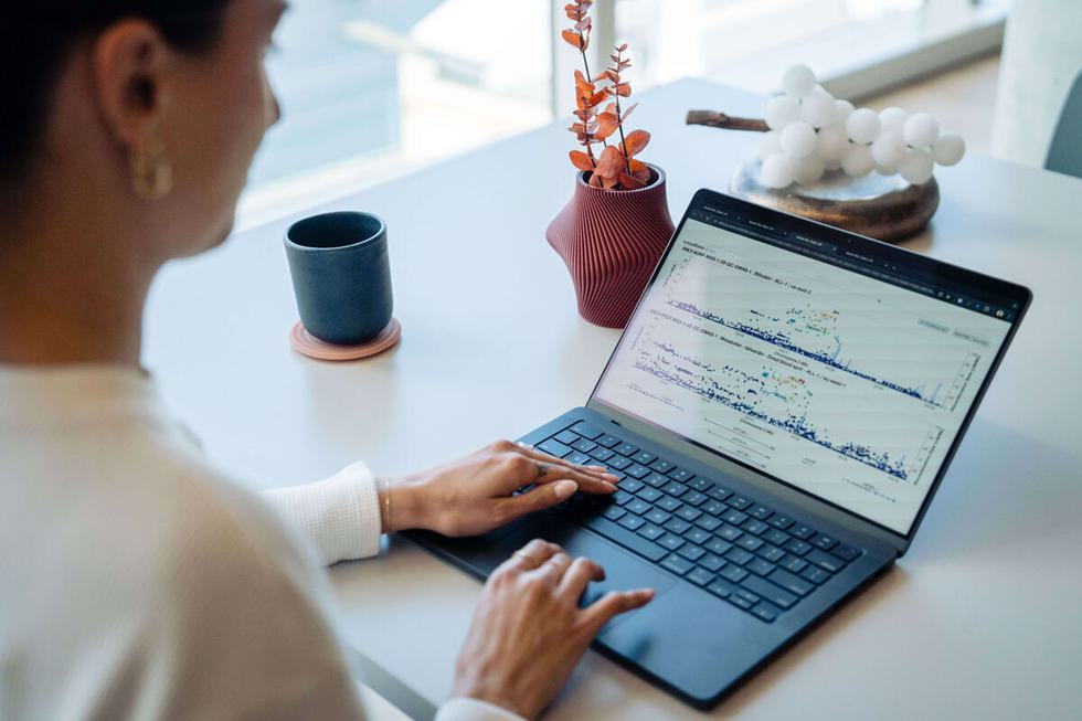 A woman sitting at her laptop with a cup of coffee on the desk