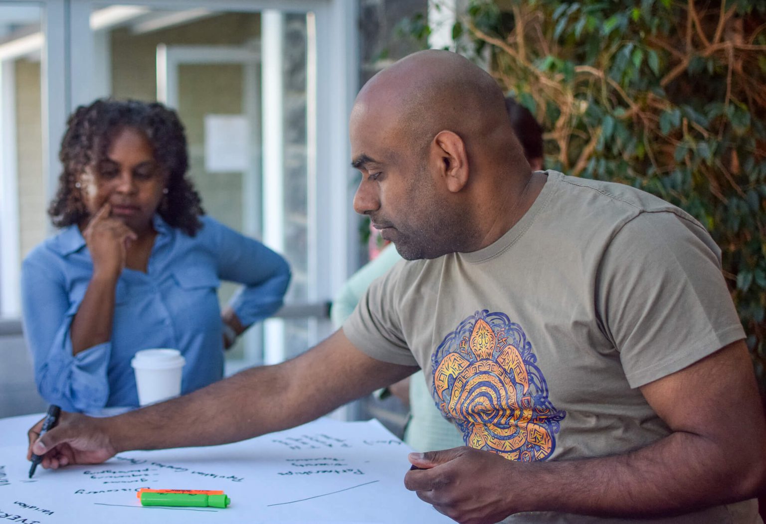 Two men in discussion seated at a table looking at a shared document