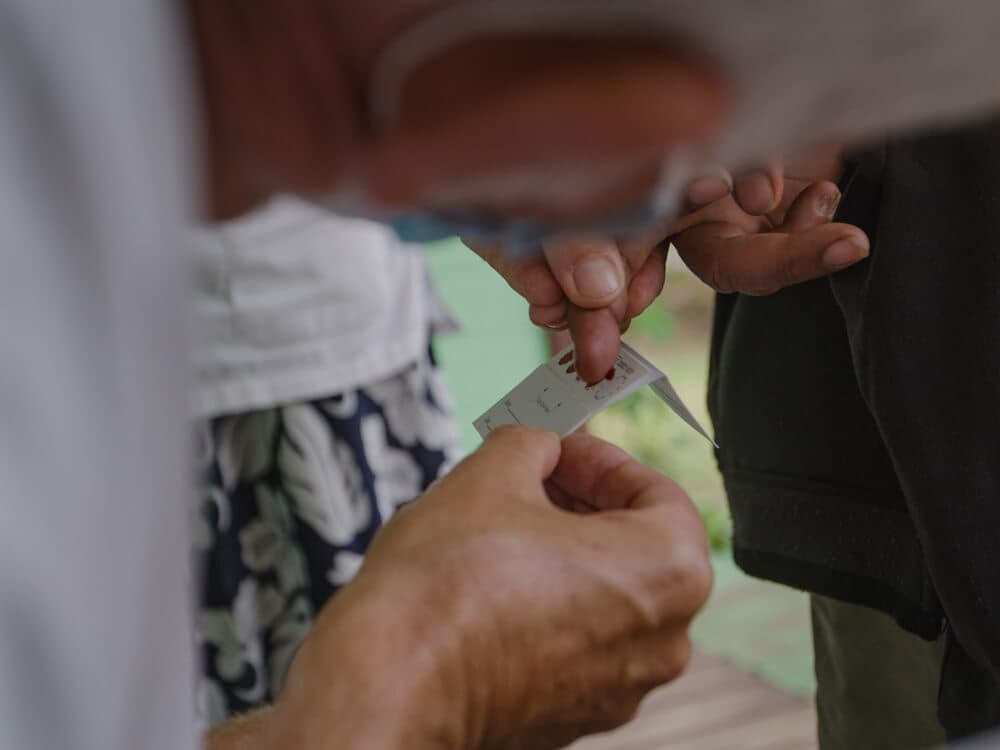 A close up of hands with a blood test being administered.