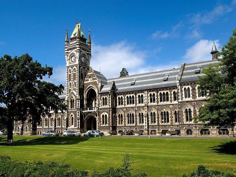 University of Otago A large building with a tree-lined lawn and a blue sky