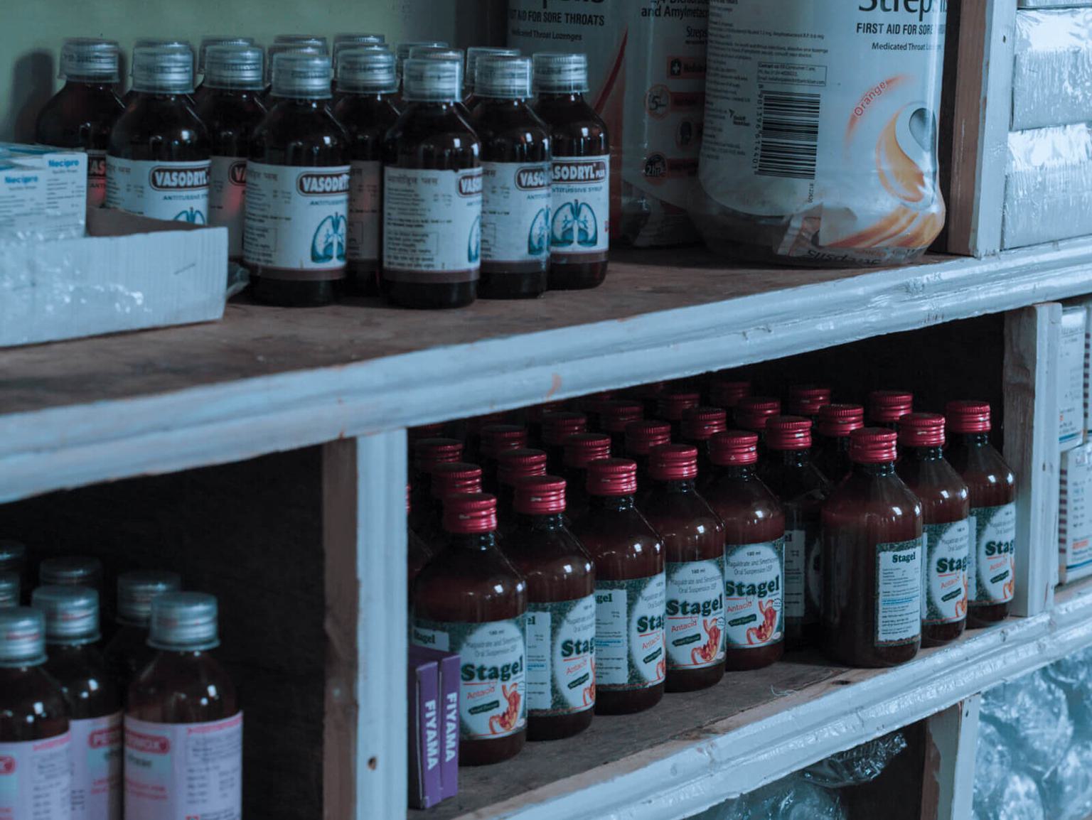 Various bottles and other medicinal products displayed on a store shelf.
