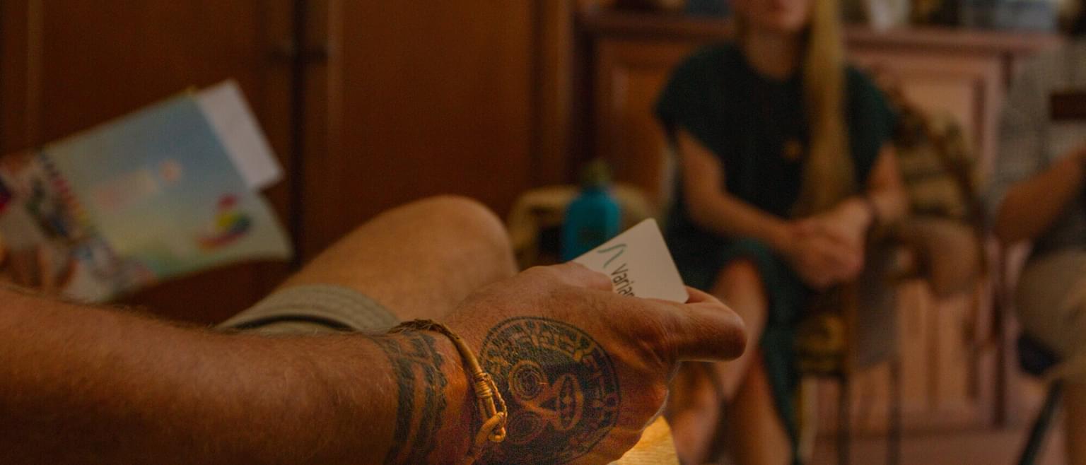 A tattooed hand holding a card with a Variant Bio logo.